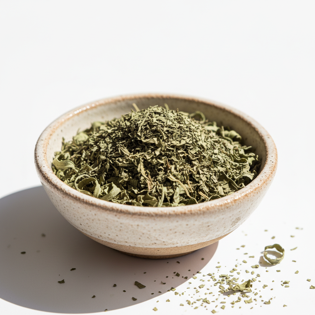 Dried basil herb in bowl on white background