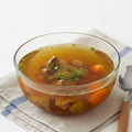 Beef broth in glass bowl on white background